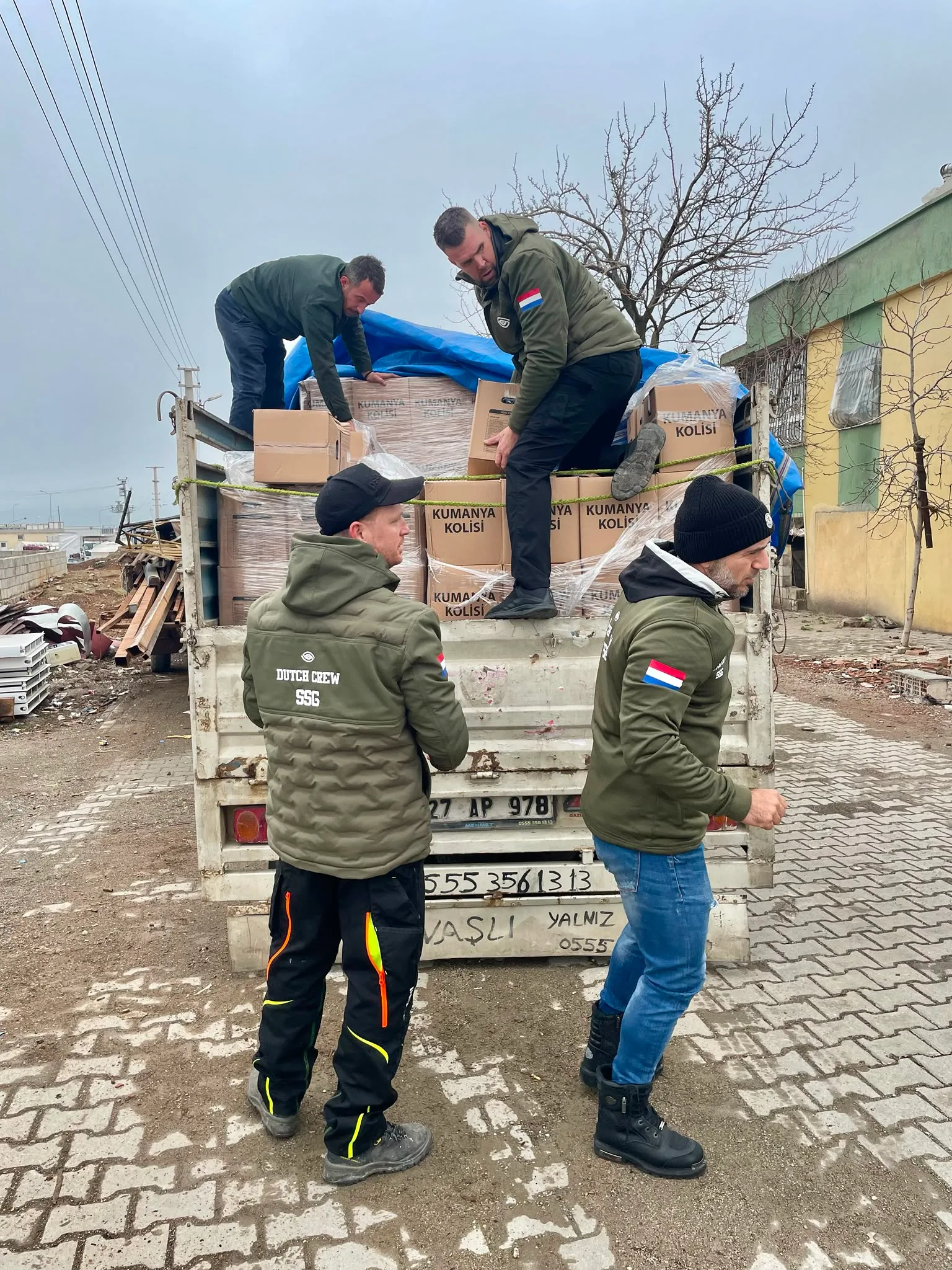 Medewerkers van SSG laden dozen met voedselpakketten van een vrachtwagen tijdens de hulpactie in Turkije