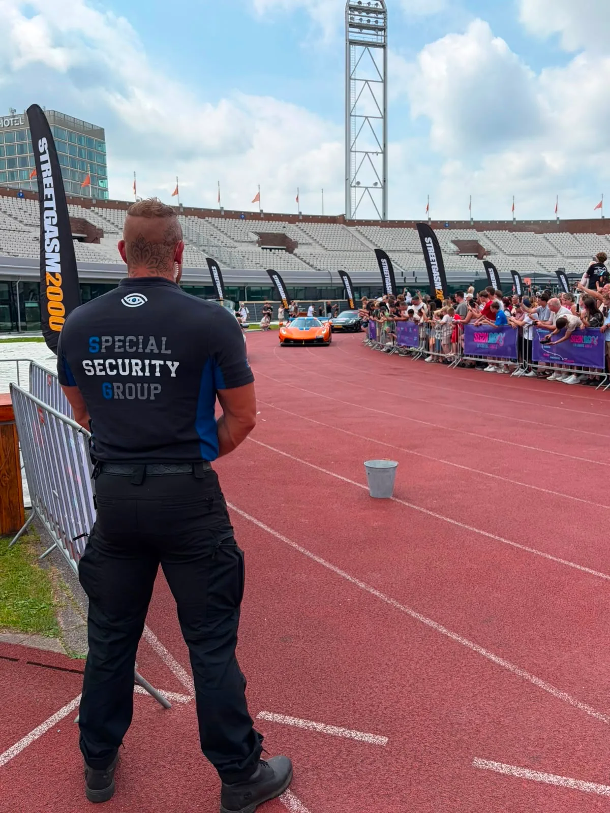 Twee beveiligers van SSG houden toezicht in een evenementenhal tijdens een sportevenement