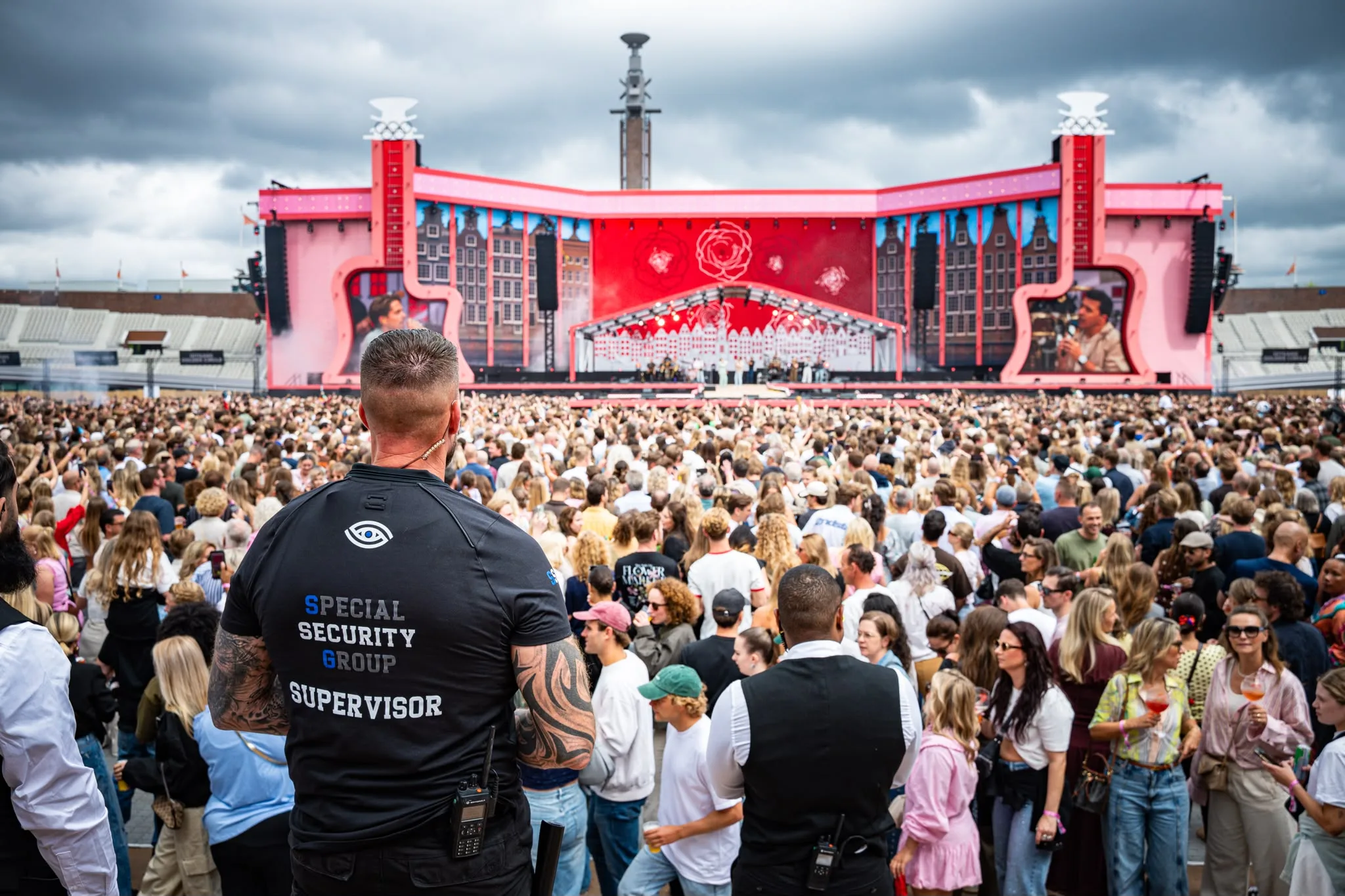 Vier beveiligers van SSG houden toezicht op het publiek tijdens een concert in een stadion